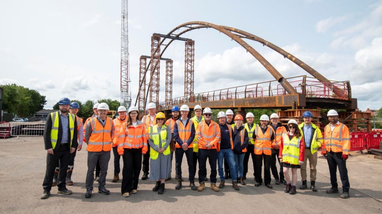 A group of people stood in front of a bridge
